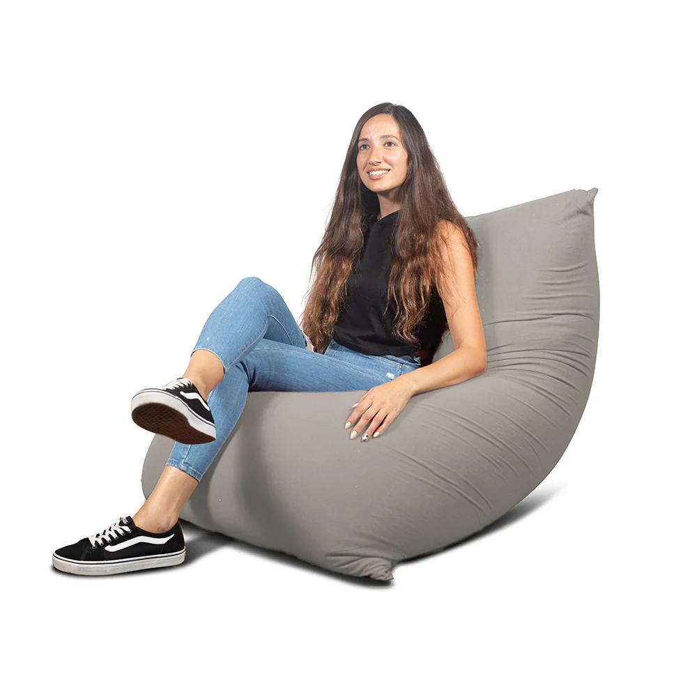 אישה יושבת על פוף גדול אפור